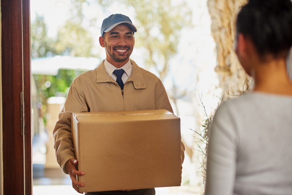 Shot of a delivery man making a delivery to a customer at her home